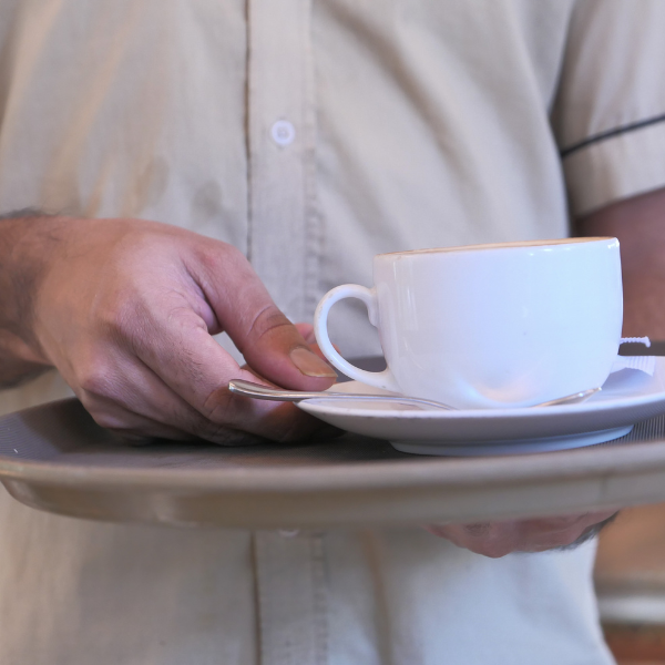waiter holding a coffee cup in a tray