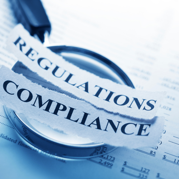 regulations and compliance strips on magnifying glass