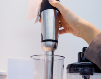A hand operating a blender