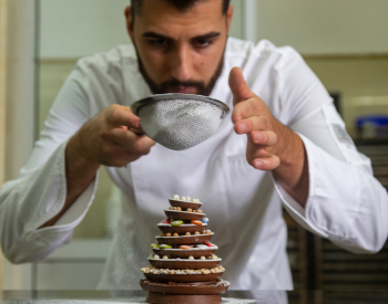 Pastry chef adding details to dessert