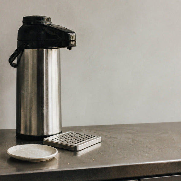 Airpot coffee dispenser at a self-serve coffee station keeping brewed coffee hot for hours