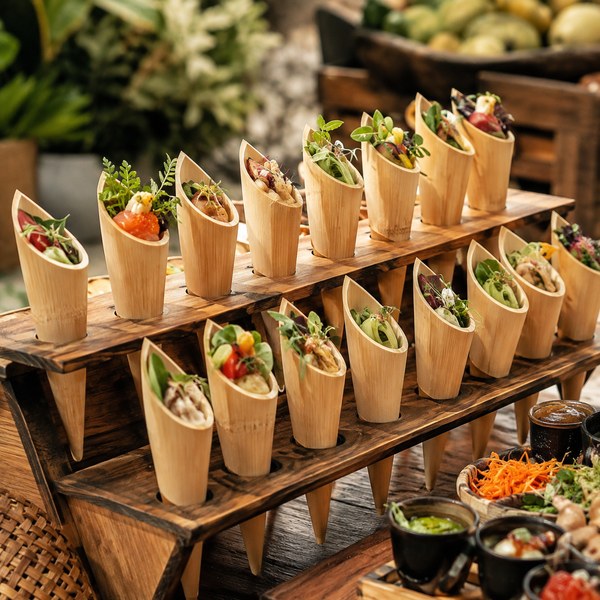 Multi-port bamboo cone stand holding rows of bamboo food cones at a buffet station