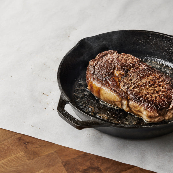 Ribeye searing in a cast iron skillet, the best pan for steak crust and heat retention