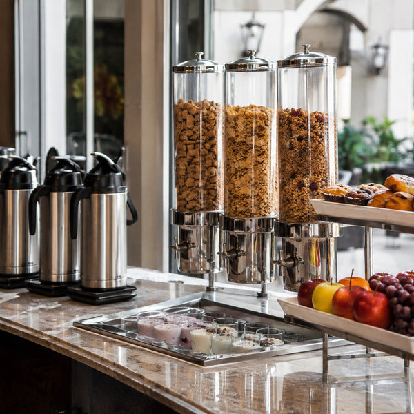Continental breakfast setup equipment including cereal dispensers, coffee airpots, and display risers