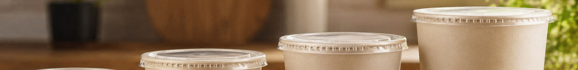 Four disposable soup containers with lids in 8, 12, 16, and 32 oz sizes lined up by size