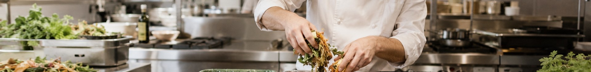 Chef sorting kitchen waste into compost bins, illustrating ESG food practices in a commercial kitchen