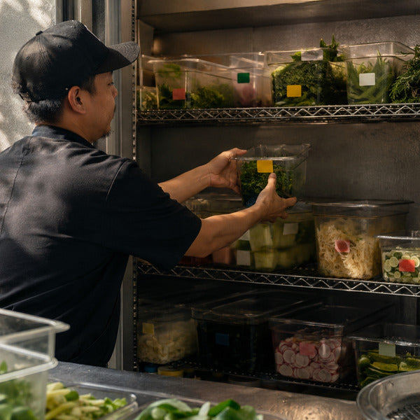 FIFO food rotation with date stickers on shelving in a walk-in cooler