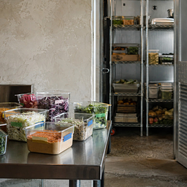 FIFO-labeled food storage containers in a walk-in cooler used to reduce food waste in restaurants