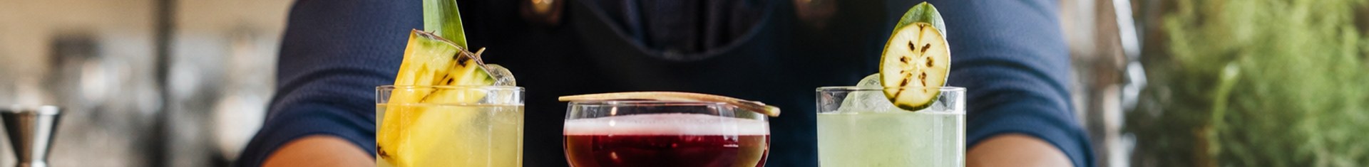 Bartender presenting signature cocktails, a core food and beverage marketing strategy for beverage programs