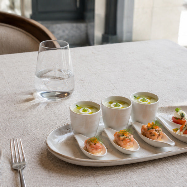 Chilled soup shooters and tasting spoons plated as an amuse bouche course