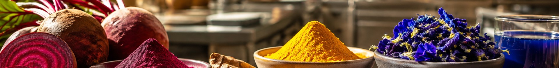 Natural food dyes from beet, turmeric, and butterfly pea flower arranged in a commercial kitchen
