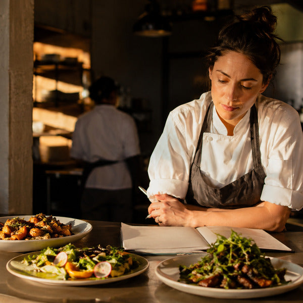 Chef reviewing plant-based sample plates on a prep counter