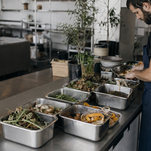 Back-of-house sorting station with compost bins helping reduce food waste in a commercial kitchen