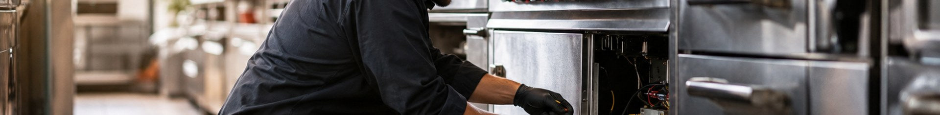 Technician performing restaurant equipment maintenance on a commercial kitchen line