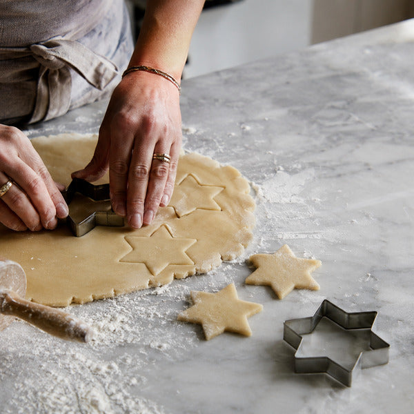 Pressing a star cookie cutter straight down into rolled dough