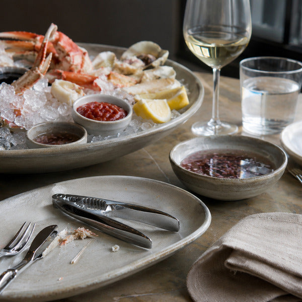 Raw bar service with crab crackers, seafood forks, and eco-friendly servingware for sustainable seafood