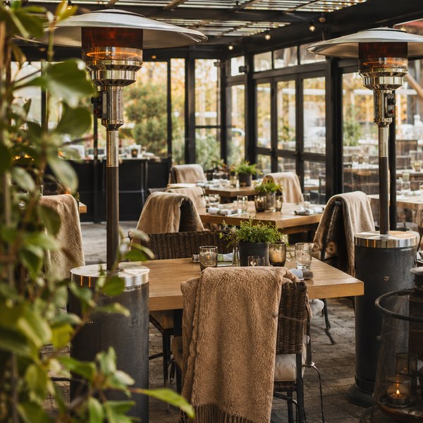 Enclosed restaurant patio with heaters and blankets set up to prepare the restaurant for winter service